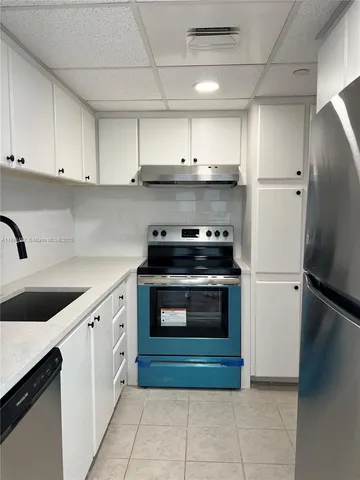 a kitchen with a refrigerator sink and cabinets