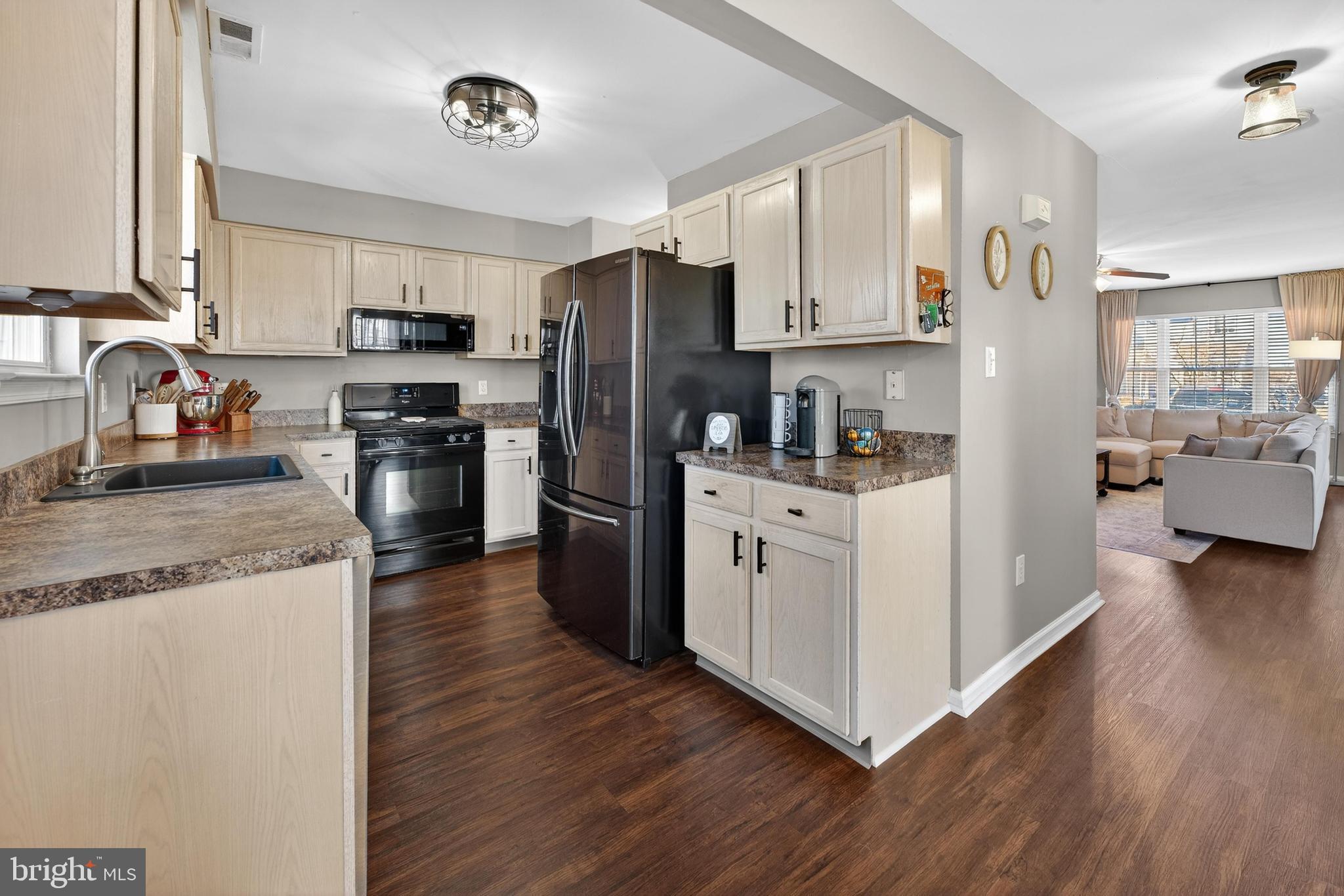137 Pendragon Way Mantua, NJ 08051 - Photo 7 of 25 a kitchen with stainless steel appliances granite countertop a refrigerator a stove top oven a sink and dishwasher with wooden floor