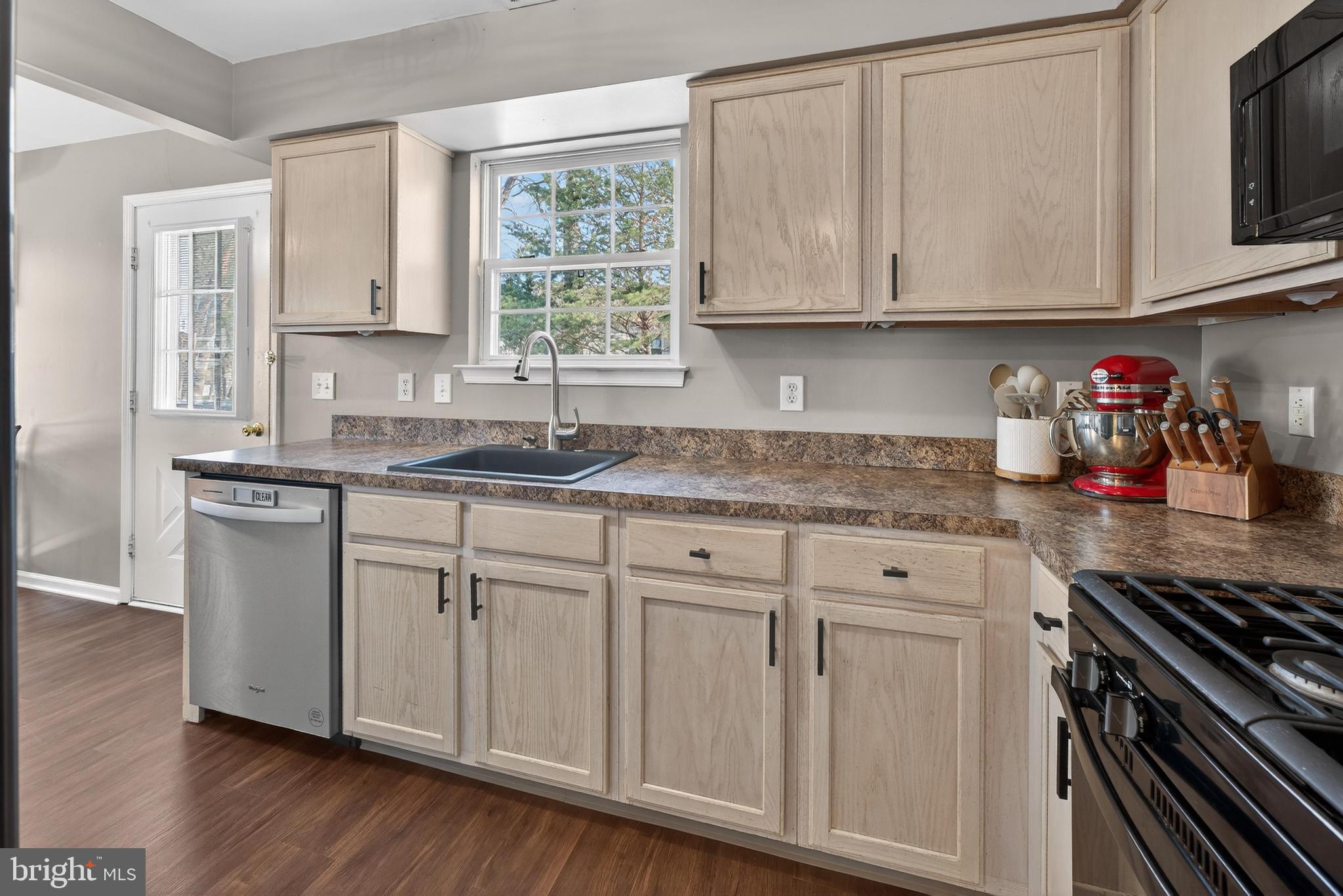 137 Pendragon Way Mantua, NJ 08051 - Photo 9 of 25 a kitchen with stainless steel appliances granite countertop a sink dishwasher stove and white cabinets with wooden floor