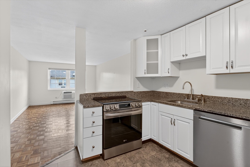 881 Main Street, Unit 9 Walpole, MA 02081 - Photo 2 of 23 a kitchen with granite countertop white cabinets and white appliances