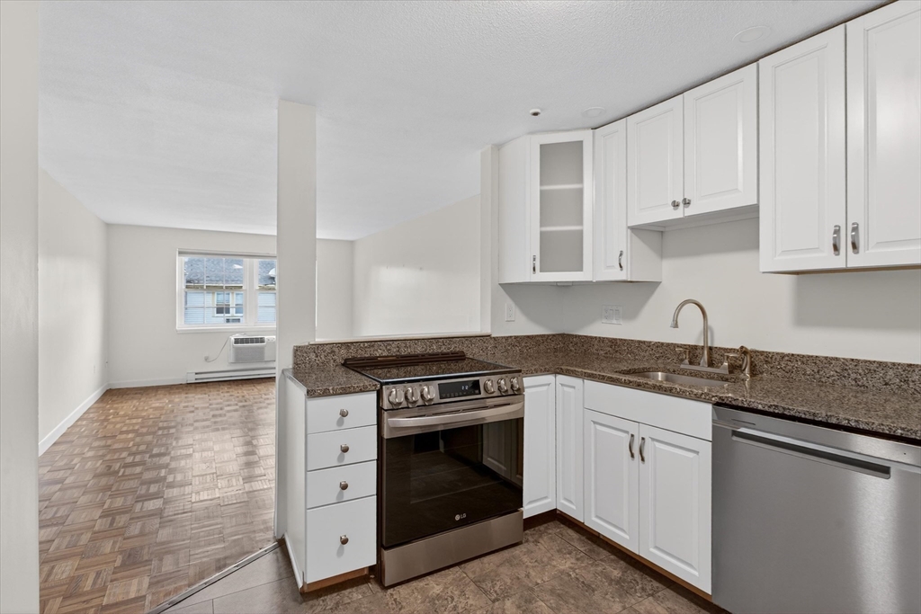 881 Main Street, Unit 9 Walpole, MA 02081 - Photo 3 of 25 a kitchen with granite countertop white cabinets and white appliances