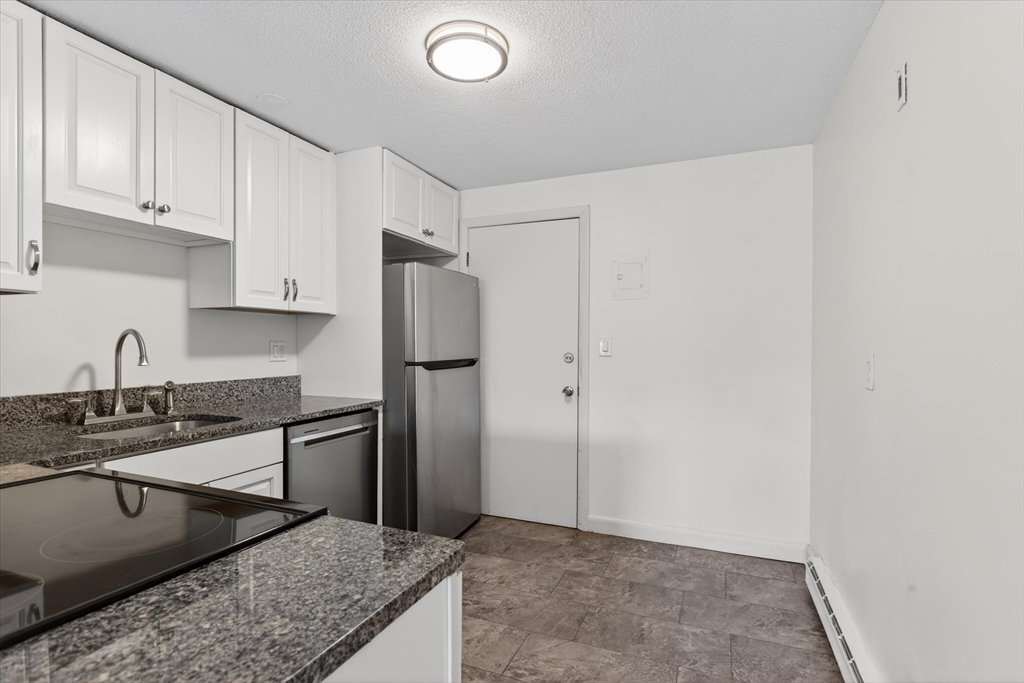 881 Main Street, Unit 9 Walpole, MA 02081 - Photo 4 of 25 a kitchen with stainless steel appliances granite countertop a refrigerator and a sink