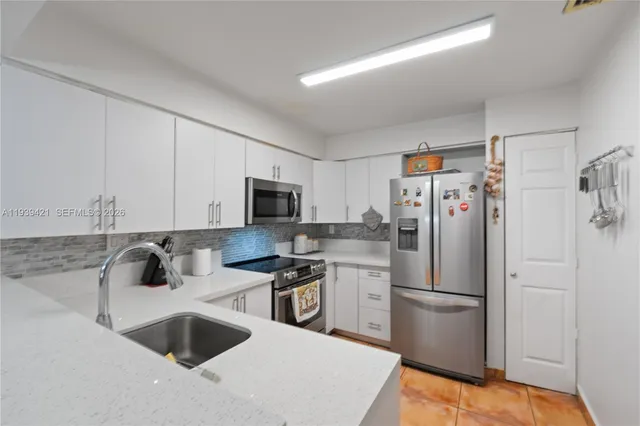 a kitchen with stainless steel appliances a refrigerator sink and microwave