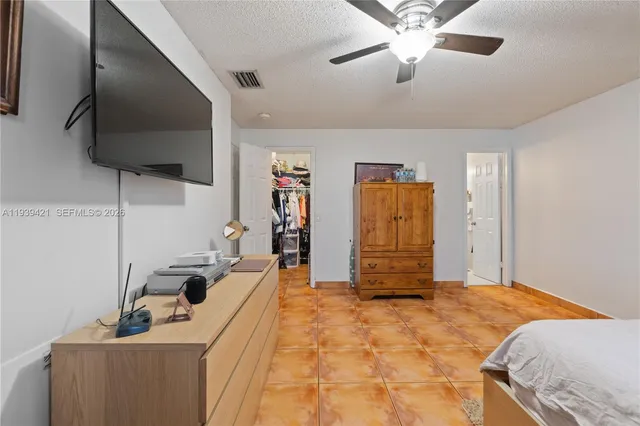 a bedroom with a bed and a flat tv screen on the dresser