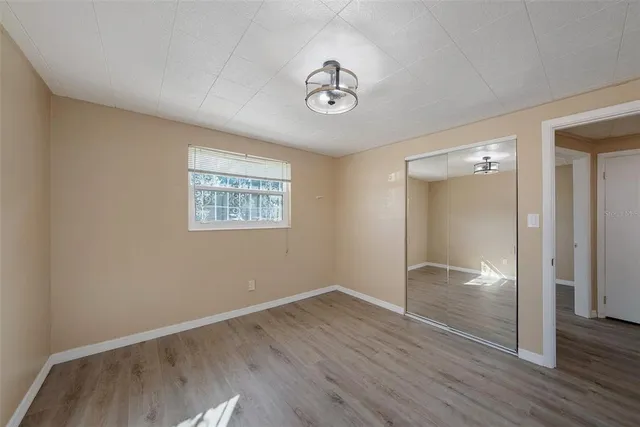 a view of empty room with wooden floor and window