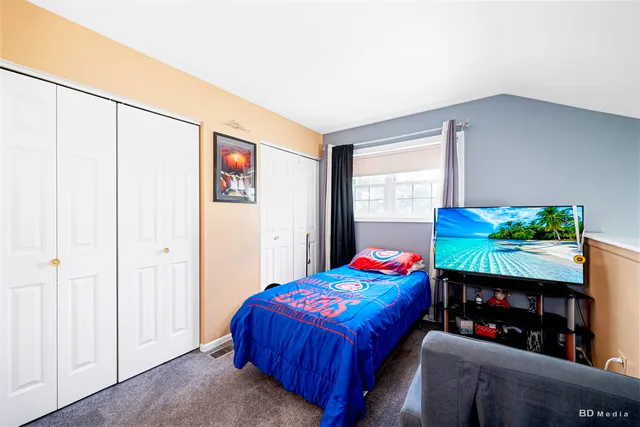 a bedroom with a bed a dresser and a window