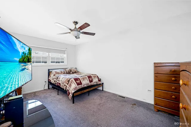 a bedroom with a bed and a ceiling fan