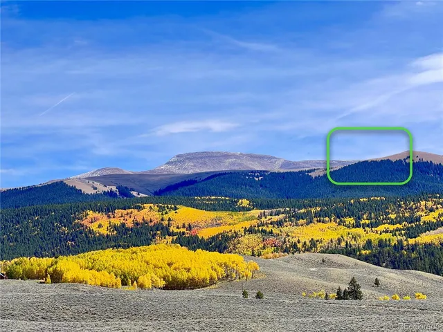 a view of a dry yard with wooden fence