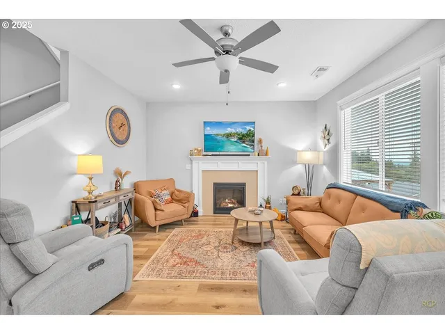 a living room with furniture a fireplace and a large window