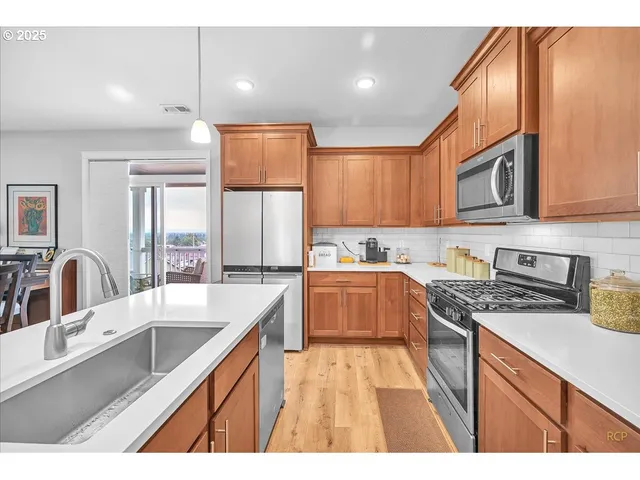 a kitchen with stainless steel appliances granite countertop a sink stove and cabinets