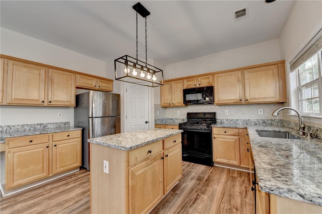 100 Hawnley Trc Northwest Suwanee, GA 30024 - Photo 25 of 58 a kitchen with stainless steel appliances granite countertop a sink stove and refrigerator