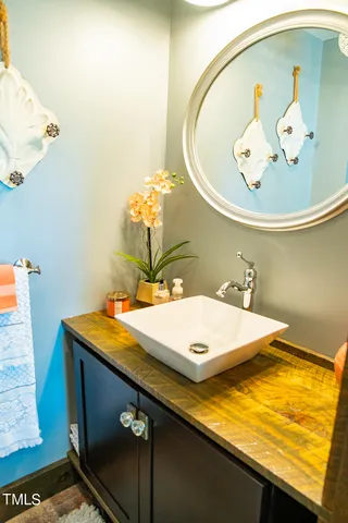 a view of a white house with a small yard and large tree