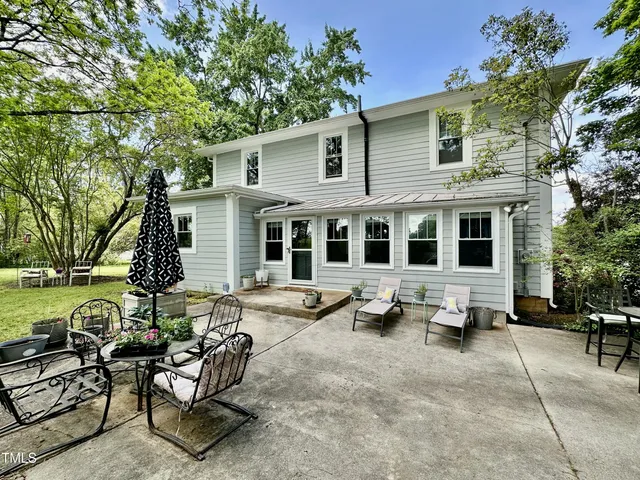 a view of a house with a large tree and a yard
