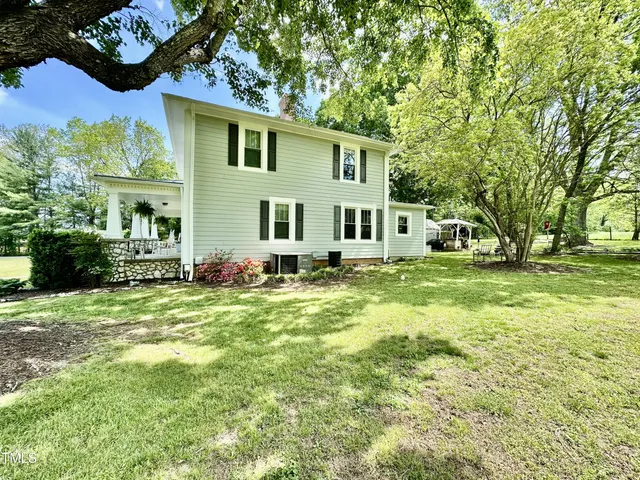 a view of a house with a yard and potted plants