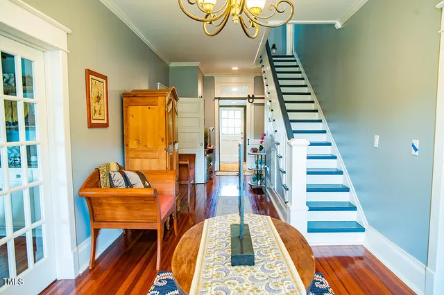 a view of a dining room with furniture a chandelier and wooden floor