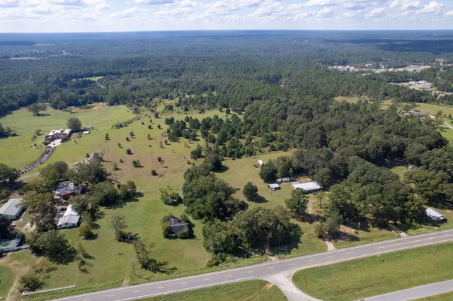 an aerial view of house with yard and mountain view in back