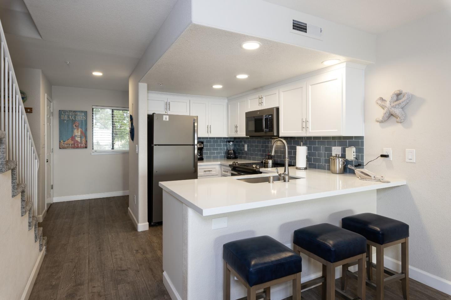 443 Seascape Resort Drive Aptos, CA 95003 - Photo 11 of 33 a kitchen with refrigerator cabinets and chairs