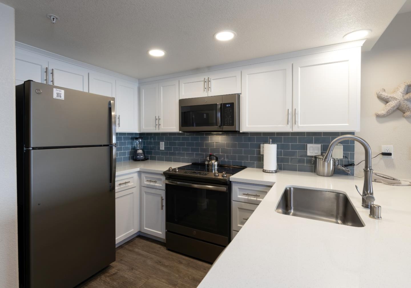 443 Seascape Resort Drive Aptos, CA 95003 - Photo 13 of 33 a kitchen with a refrigerator sink and white cabinets
