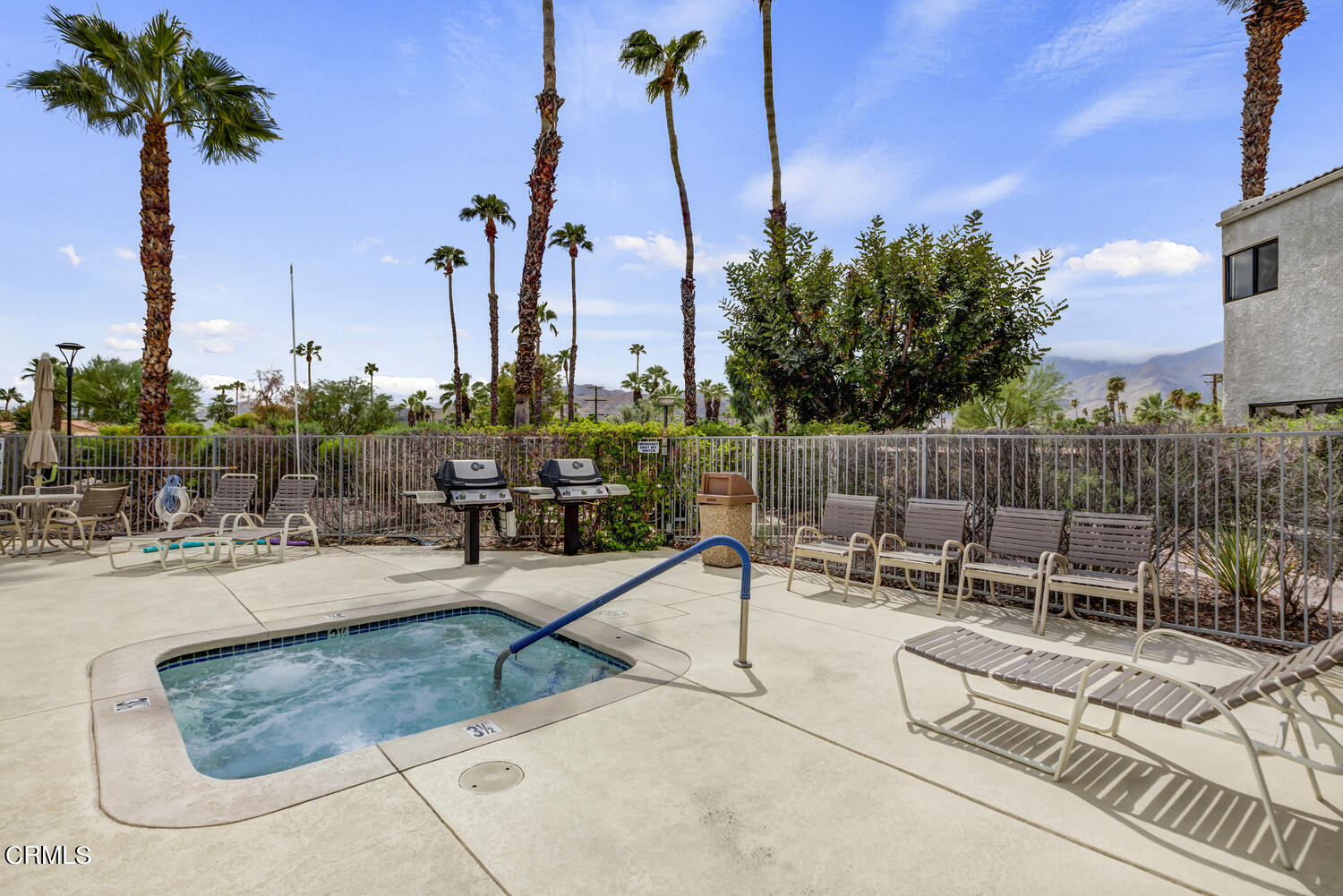 3155 Ramon Road, Unit 303 Palm Springs, CA 92264 - Photo 34 of 36 a view of a swimming pool with chairs in patio