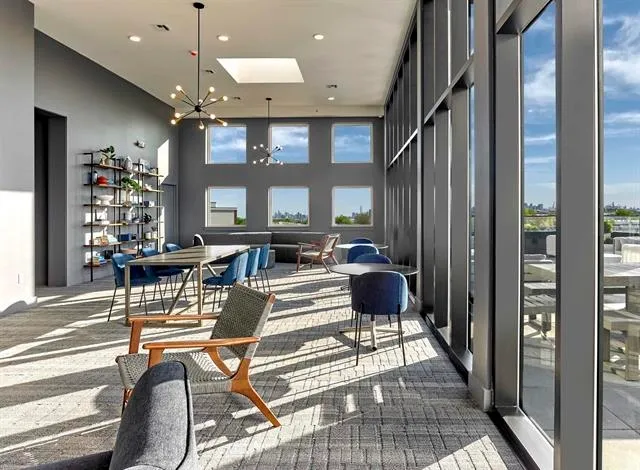 a living room with patio furniture and a large window