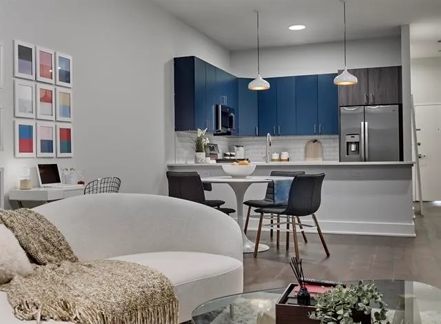a living room with a couch and a dining table with kitchen view