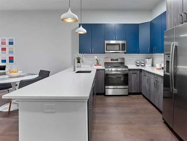 a kitchen with stainless steel appliances a stove a sink and a refrigerator
