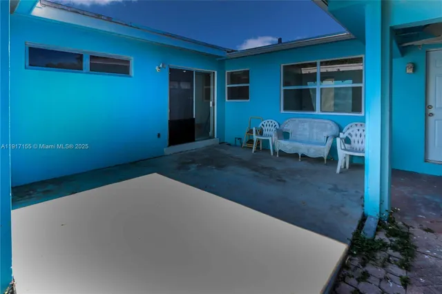 a view of a house with backyard and sitting area