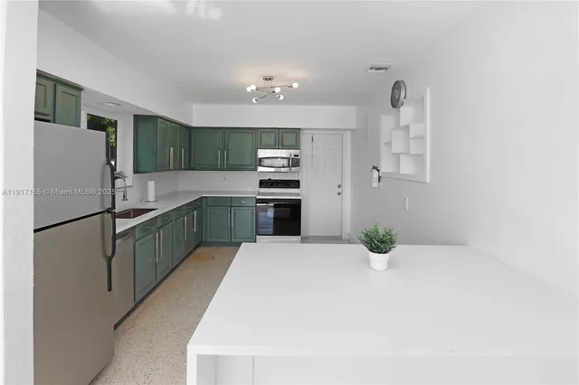 a kitchen with stainless steel appliances a refrigerator sink and cabinets