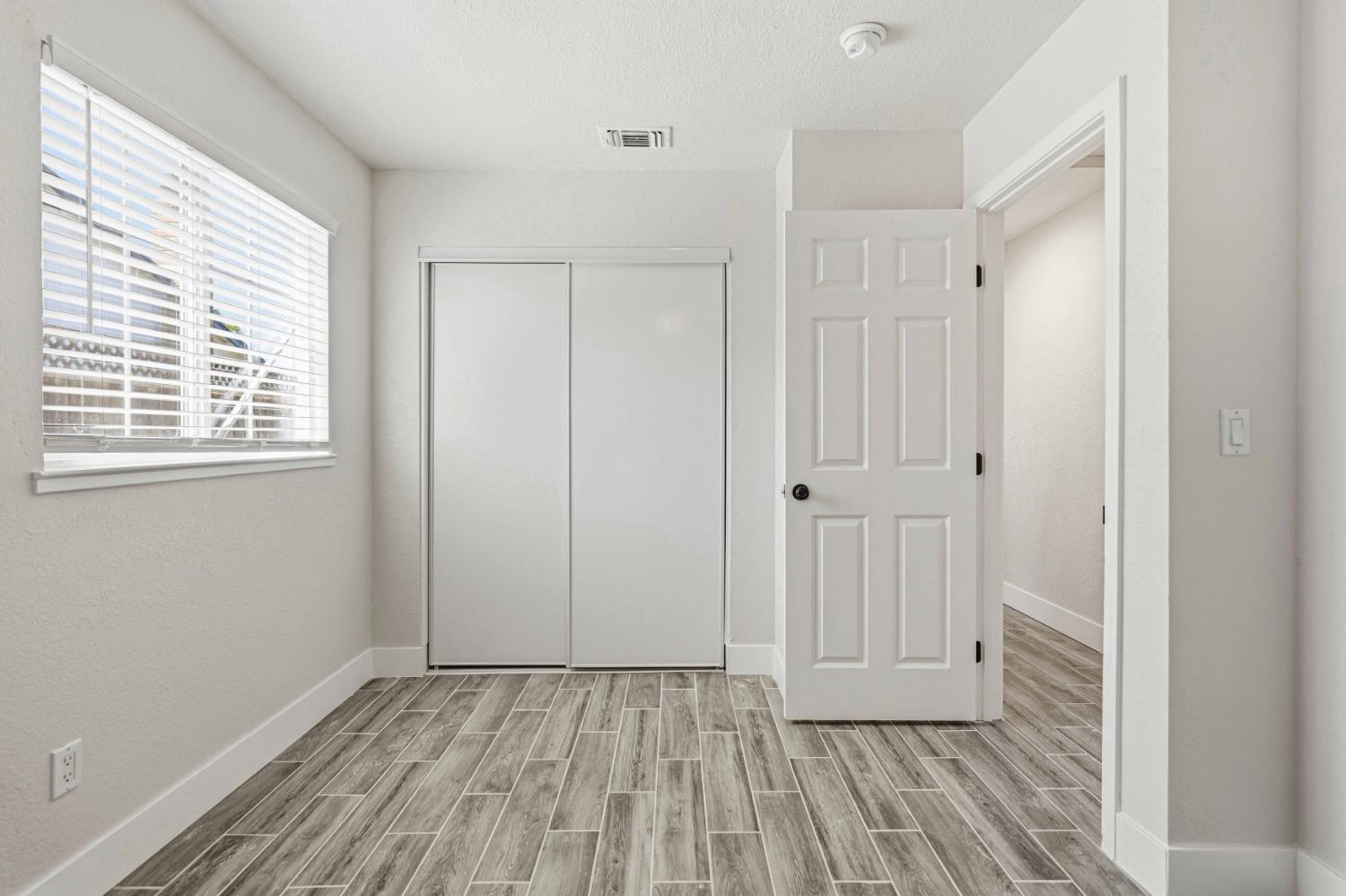 1464 Denise Drive Ripon, CA 95366 - Photo 23 of 41 a view of an empty room with wooden floor and a window