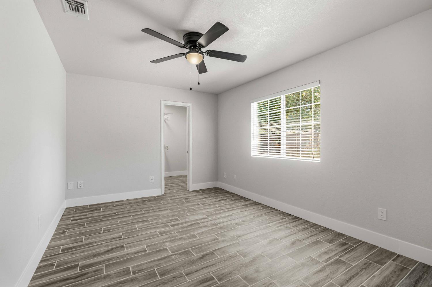 1464 Denise Drive Ripon, CA 95366 - Photo 25 of 41 an empty room with wooden floor and windows