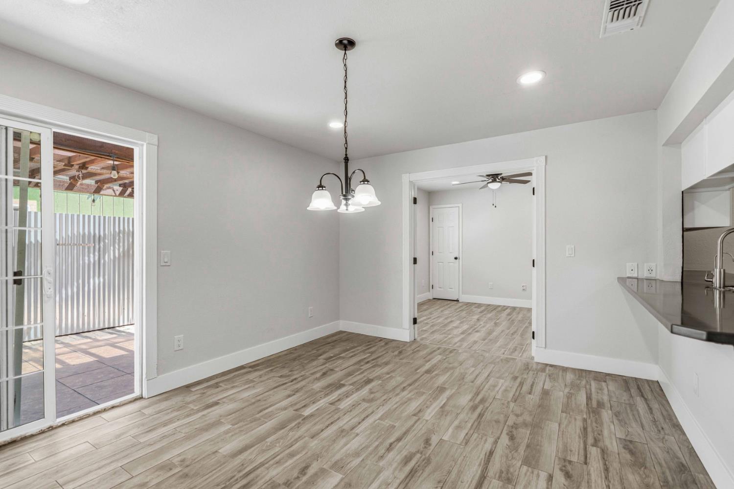 1464 Denise Drive Ripon, CA 95366 - Photo 10 of 41 a view of a room with wooden floor a ceiling fan and a window