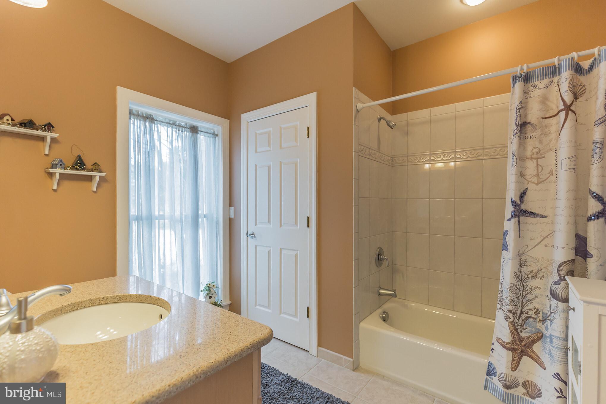 1457 Nieman Road Shady Side, MD 20764 - Photo 19 of 49 a bathroom with a granite countertop bathtub shower sink and mirror