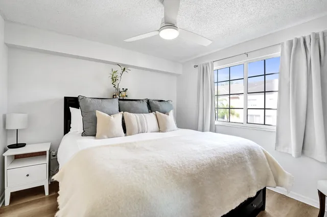a large bed sitting in a bedroom next to a window