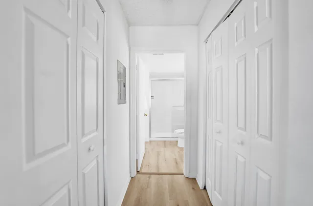 a view of a hallway with wooden floor