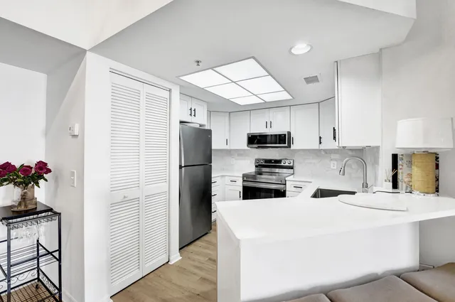a kitchen with stainless steel appliances a refrigerator sink and microwave