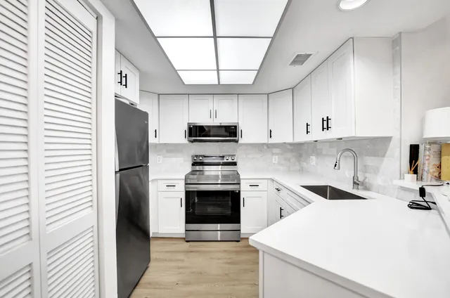 a kitchen with stainless steel appliances a stove sink microwave and cabinets