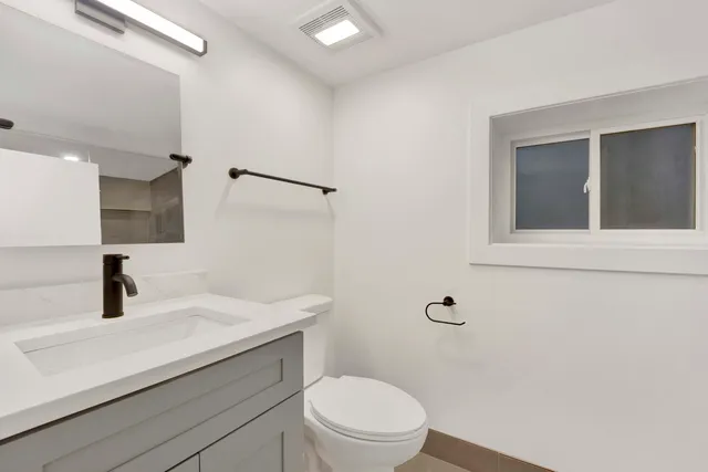 a bathroom with a sink a toilet and mirror