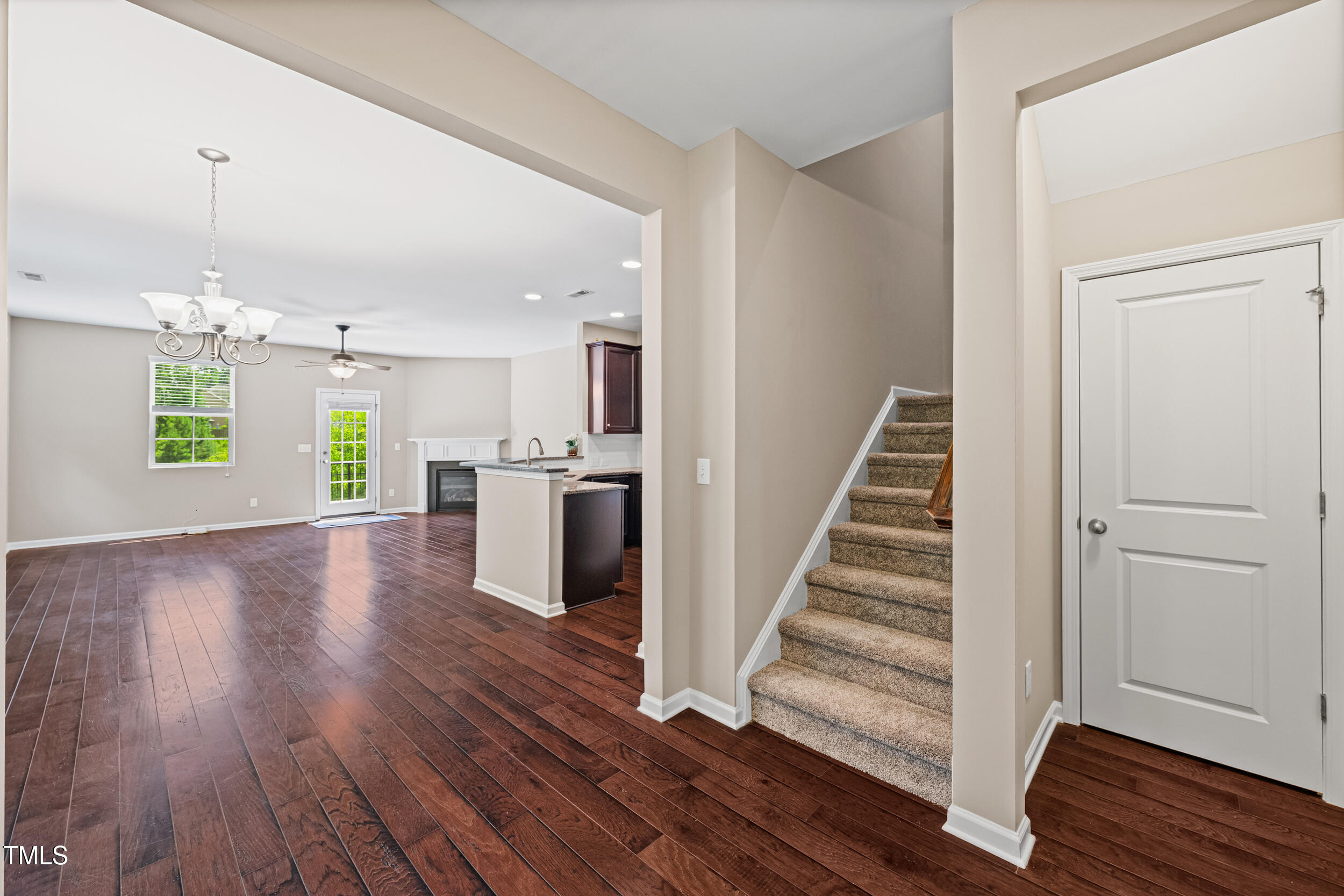 677 Wickham Ridge Road Apex, NC 27539 - Photo 8 of 34 an empty room with wooden floor staircase and windows