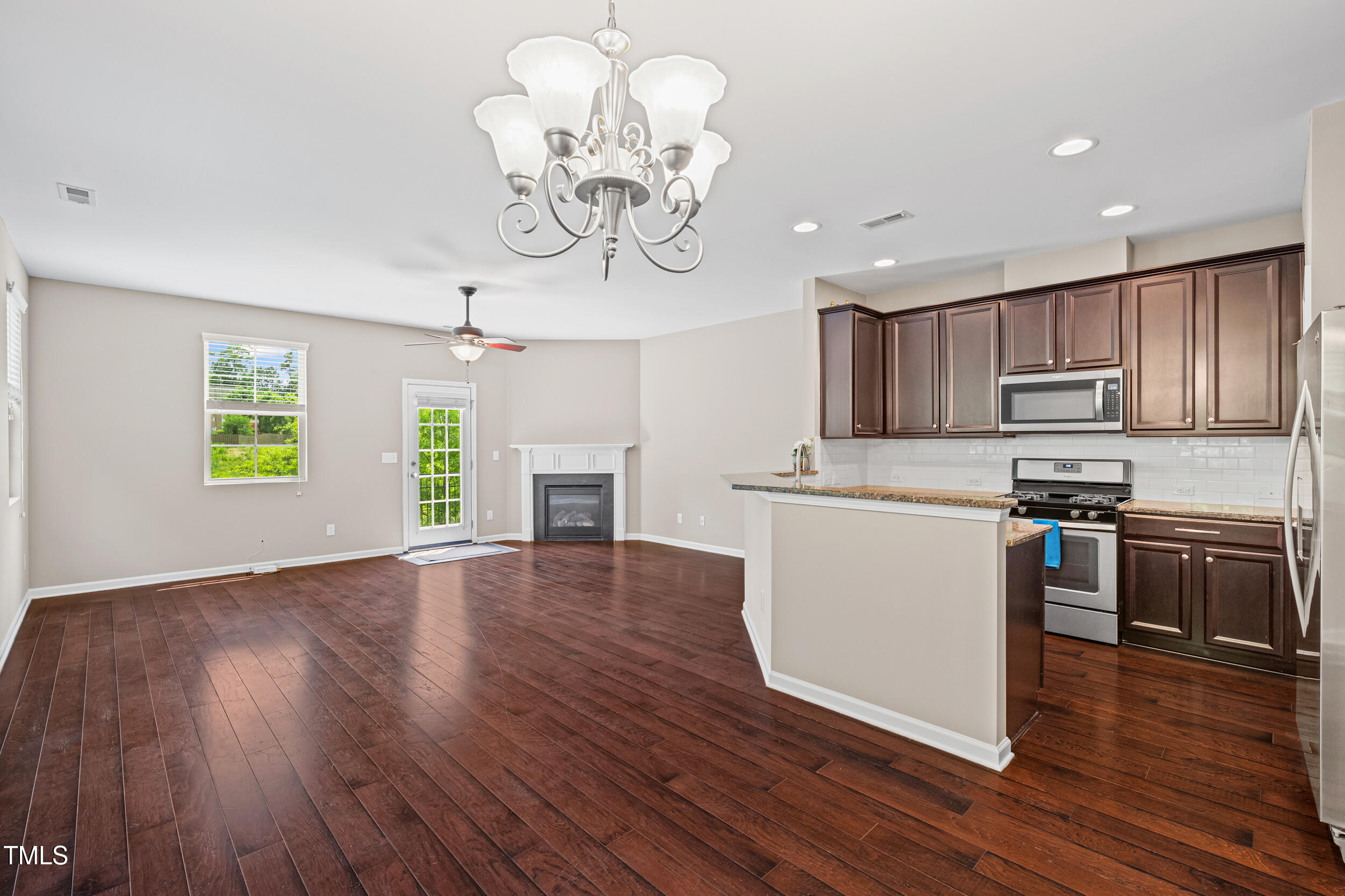 677 Wickham Ridge Road Apex, NC 27539 - Photo 9 of 34 a kitchen with a wooden floor stove top oven and refrigerator