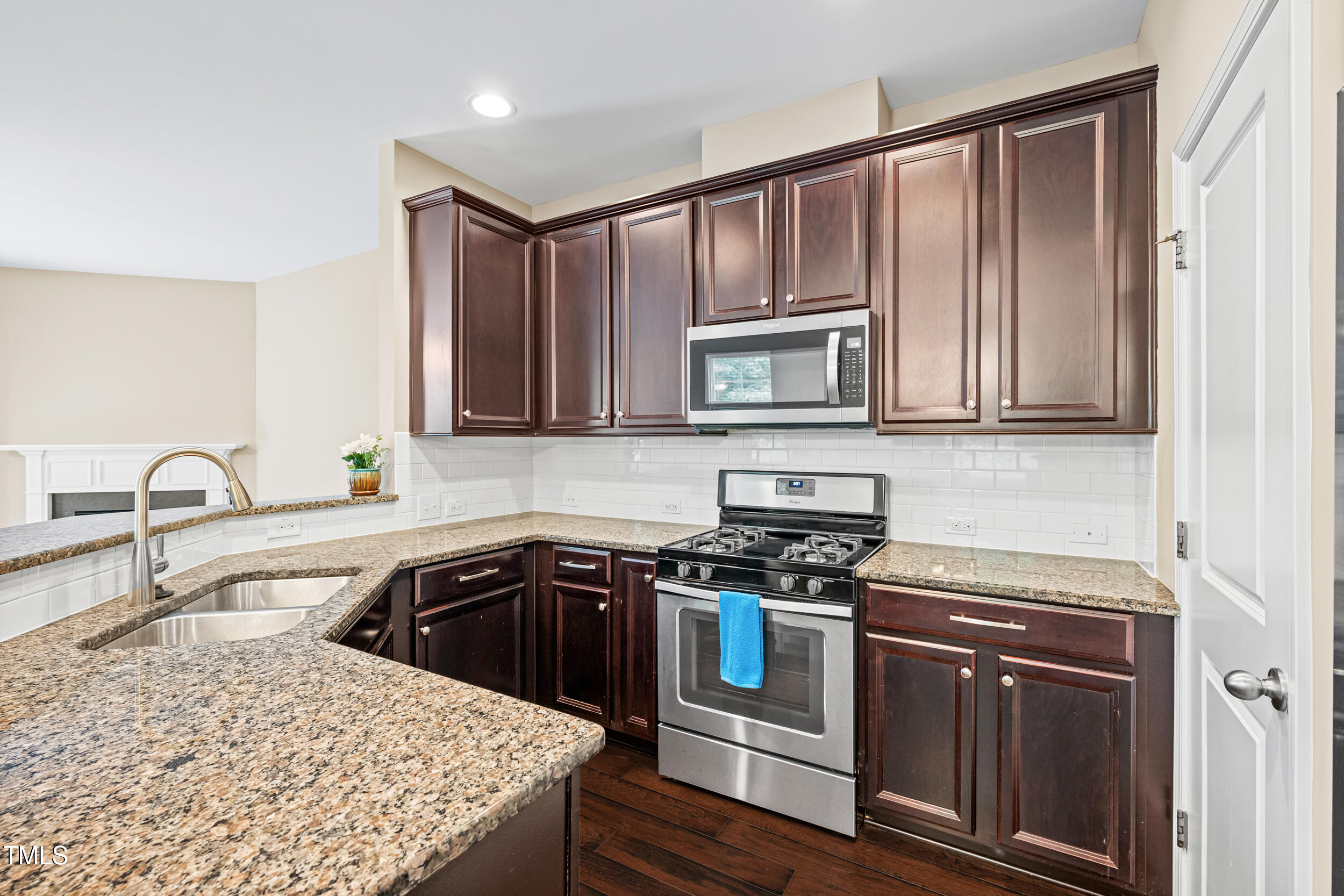 677 Wickham Ridge Road Apex, NC 27539 - Photo 13 of 34 a kitchen with stainless steel appliances granite countertop a stove a sink dishwasher and microwave with wooden cabinets