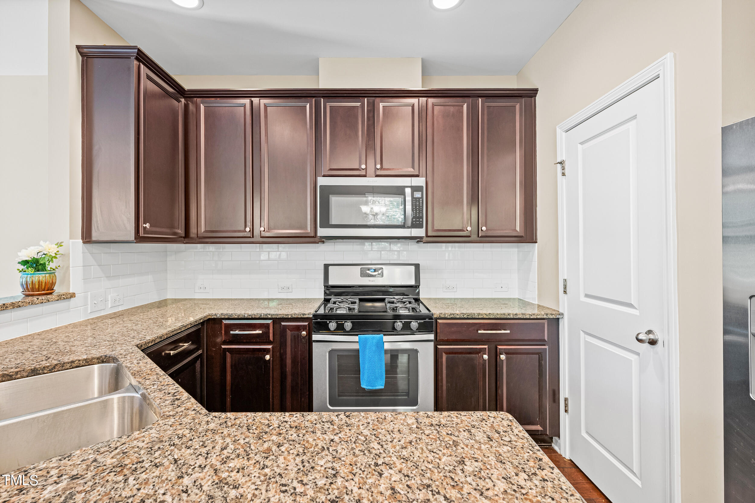 677 Wickham Ridge Road Apex, NC 27539 - Photo 14 of 34 a kitchen with stainless steel appliances granite countertop a stove a sink and a microwave