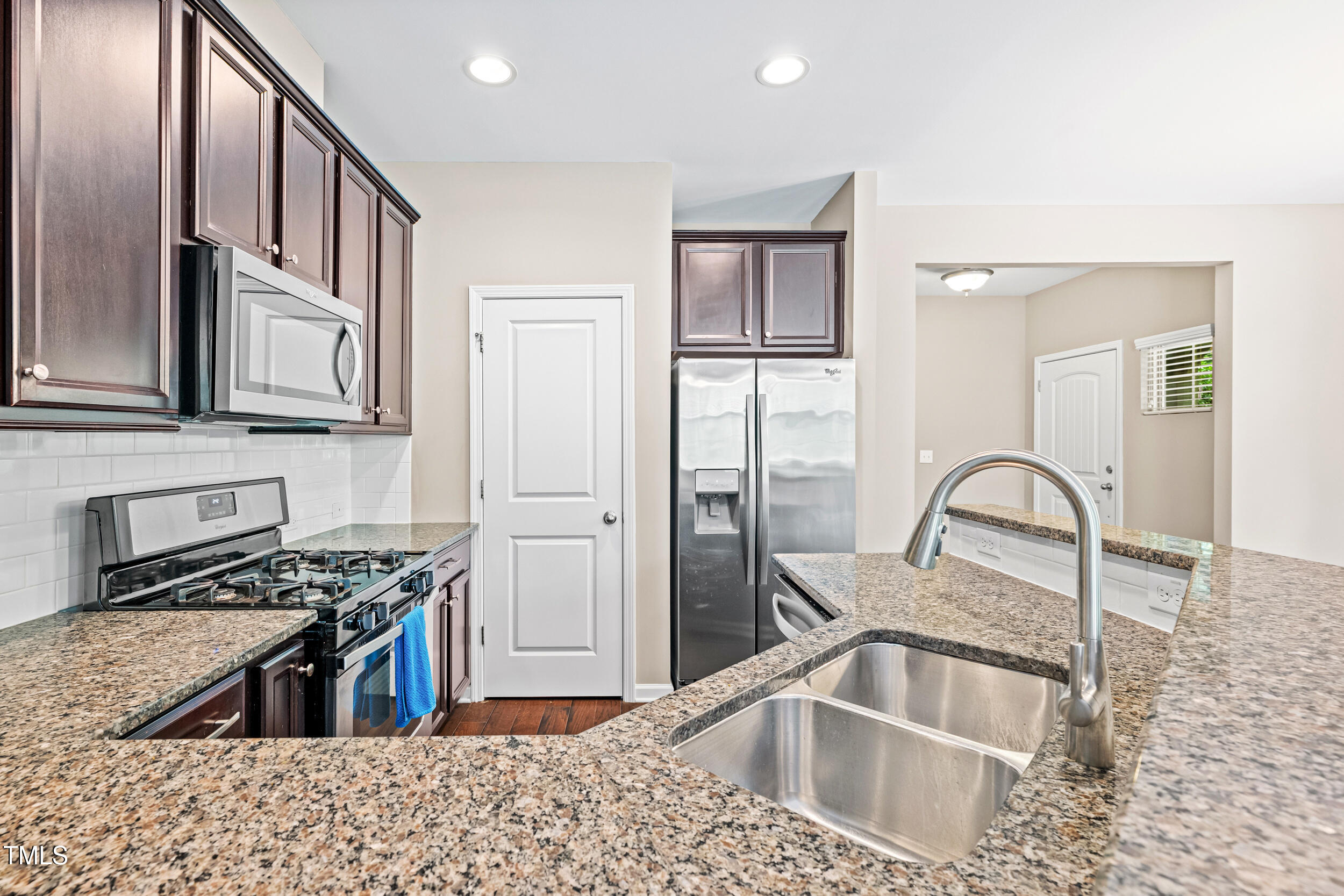 677 Wickham Ridge Road Apex, NC 27539 - Photo 15 of 34 a kitchen with stainless steel appliances granite countertop a sink stove and refrigerator