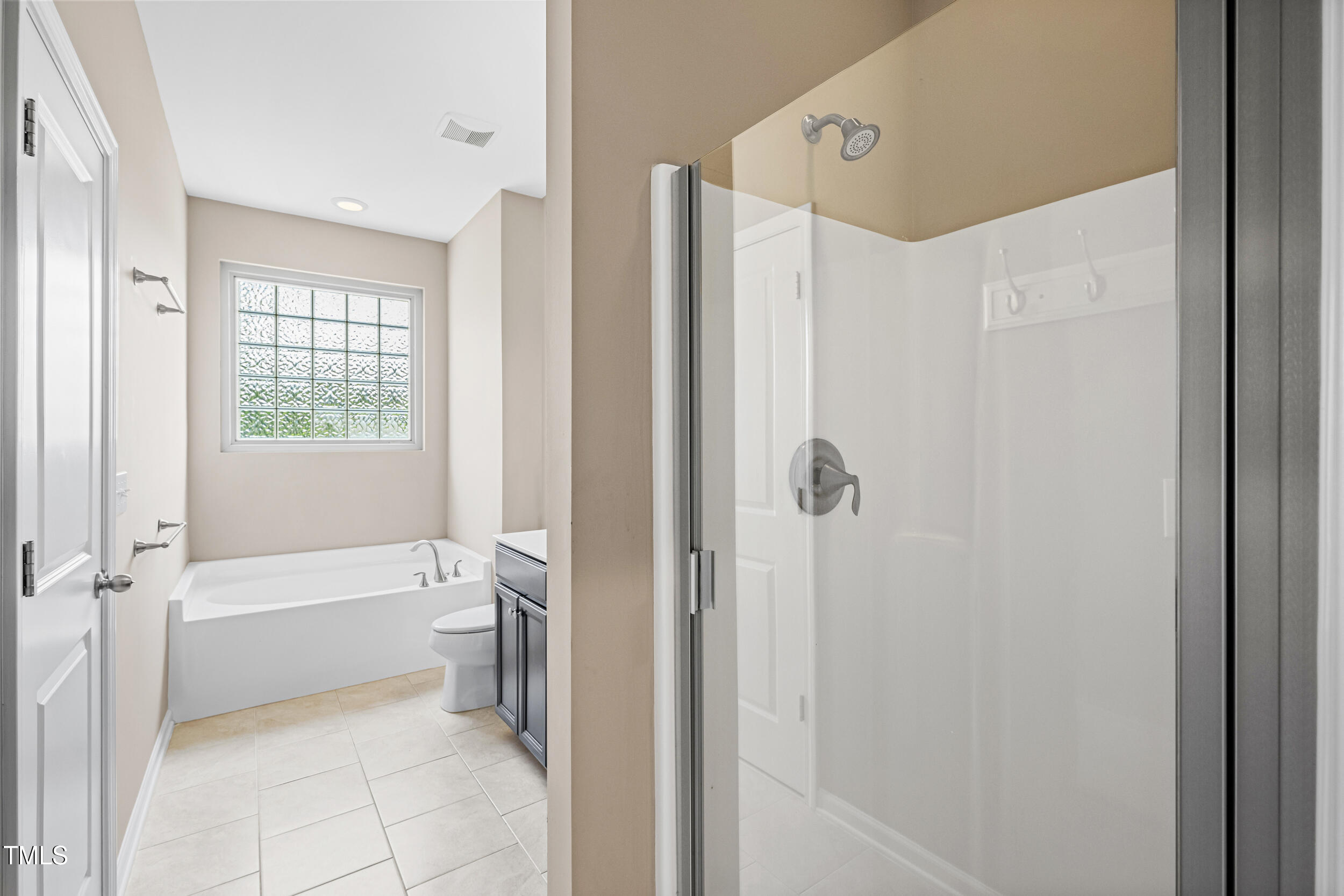 677 Wickham Ridge Road Apex, NC 27539 - Photo 25 of 34 a bathroom with a bathtub and a shower