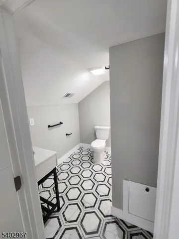 a bedroom with a bed and a lamp on the dresser