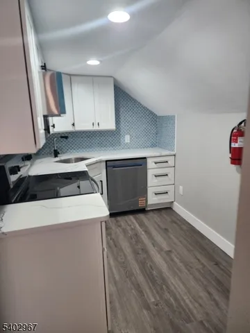 a kitchen with cabinets appliances and wooden floor
