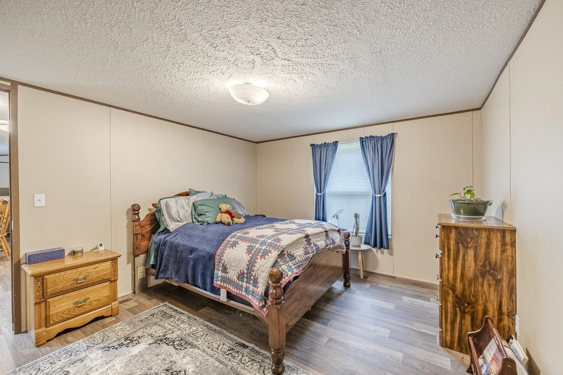 3275 Glendale Road Adamsville, TN 38310 - Photo 19 of 39 a bedroom with a bed and a dresser with wooden floor