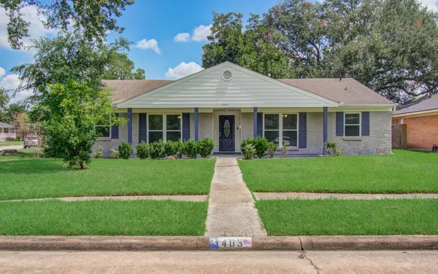 a front view of a house with a yard and trees