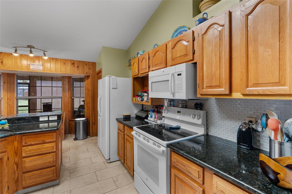 14334 Raintree Boulevard Grand Island, FL 32735 - Photo 15 of 40 a kitchen with stainless steel appliances granite countertop a stove a sink and a refrigerator