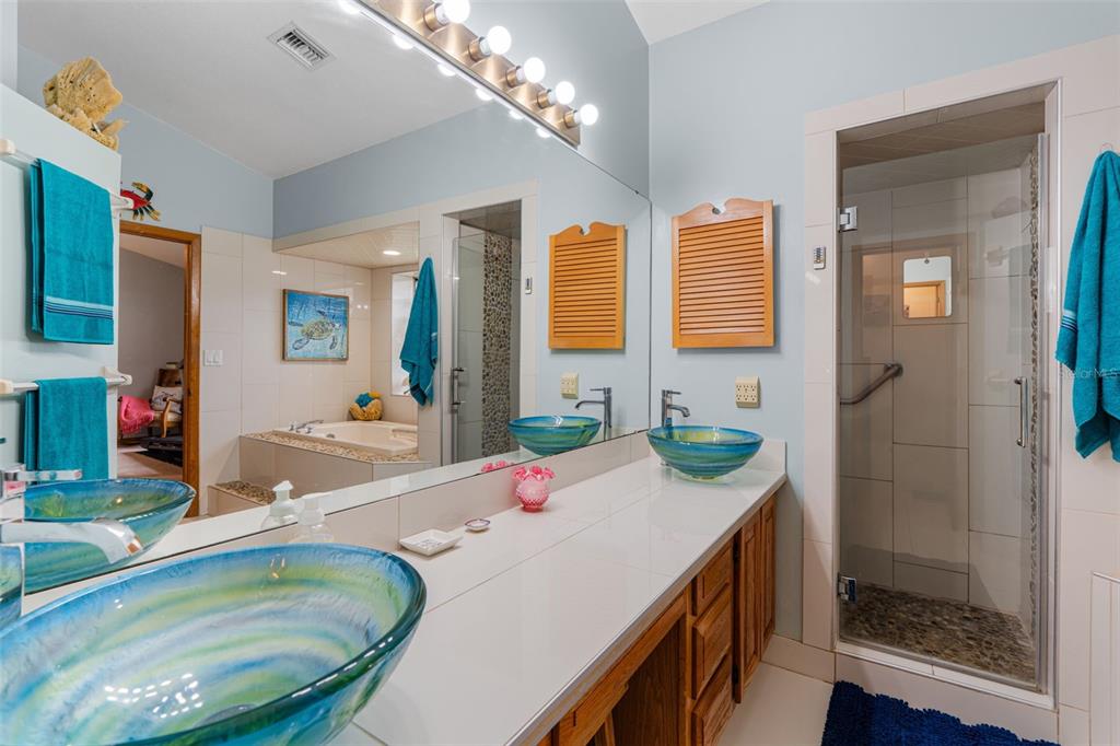 14334 Raintree Boulevard Grand Island, FL 32735 - Photo 25 of 40 a bathroom with a granite countertop sink and a mirror