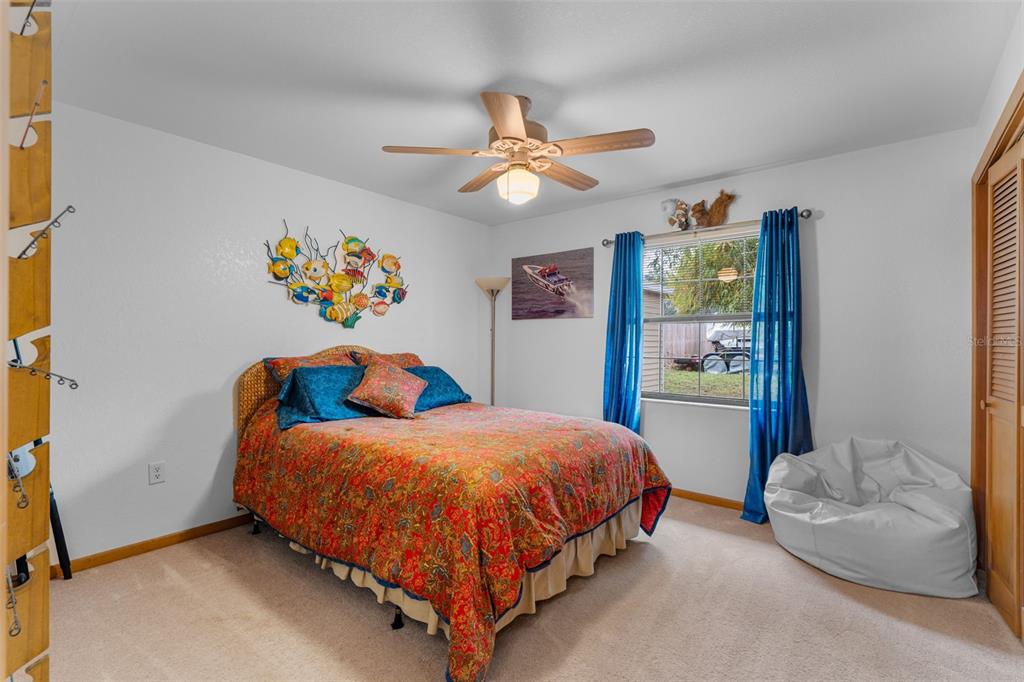 14334 Raintree Boulevard Grand Island, FL 32735 - Photo 28 of 40 a bedroom with a bed and ceiling fan